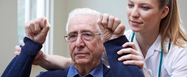Älterer Mann bei Übungen mit Arzthelferin