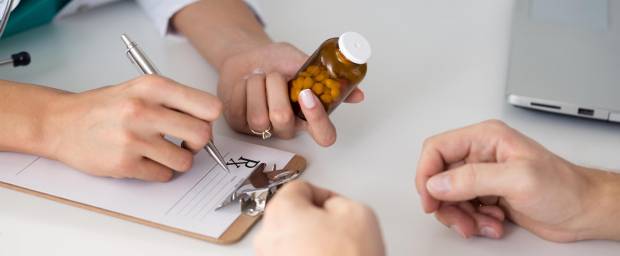 Eine Ärztin verschreibt einem Patienten Tabletten