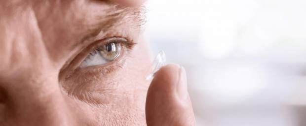 Älterer Mann setzt sich Kontaktlinsen ein