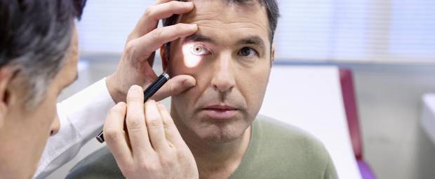 Mann bei Augenuntersuchung durch Augenarzt
