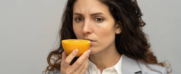 Frau riecht an einer Orange