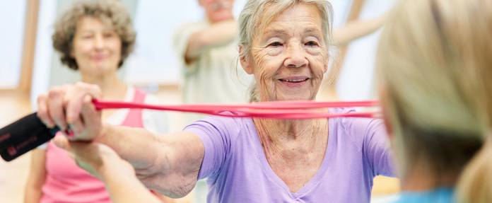 Ältere Seniorin bei Gymnastik mit Band