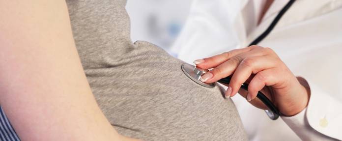 Schwangere Frau wird von Ärztin untersucht
