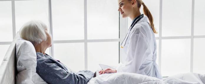 Ärztin bei Patientin am Krankenhausbett