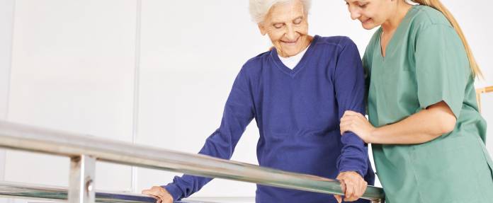 Seniorin bei Physiotherapie am Barren