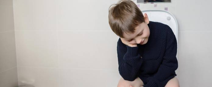 Junge sitzt auf Toilette