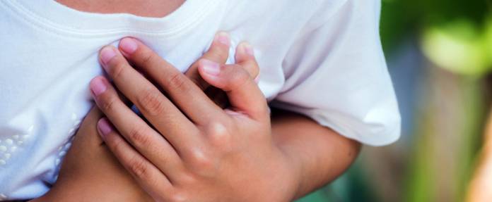 Kind fasst sich mit beiden Händen an die Brust