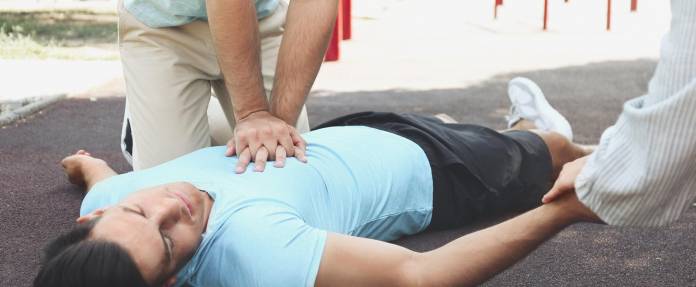 Mann wird auf der Straße durch Herzdruckmassage reanimiert