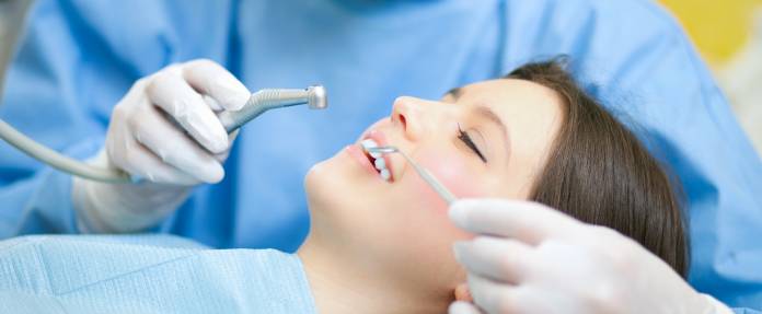 Frau während Zahnbehandlung beim Zahnarzt