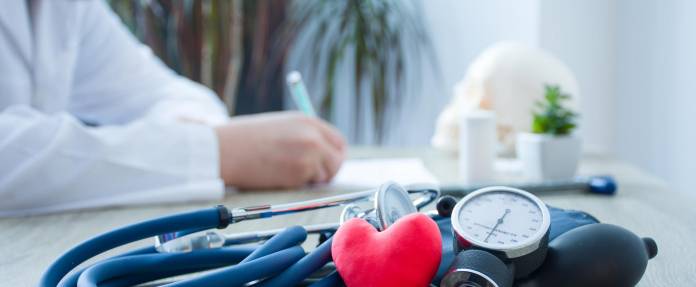 Stethoskop mit Herz und Blutdruckmessgerät auf einem Tisch liegend