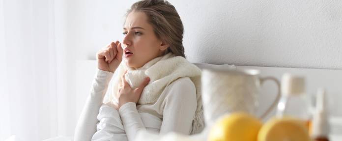 Frau mit Erkältung im Bett