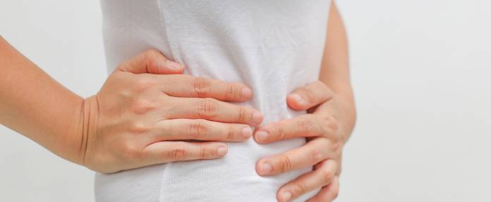 Junge Frau fasst sich um den Bauch