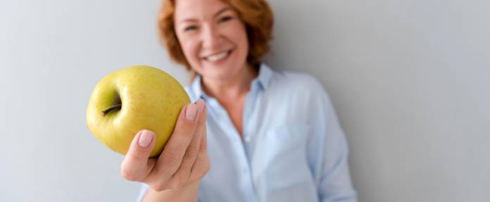 Frau mit Apfel in der Hand