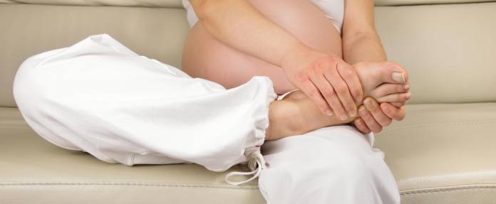 Schwangere Form schaut sich ihren Fuß an