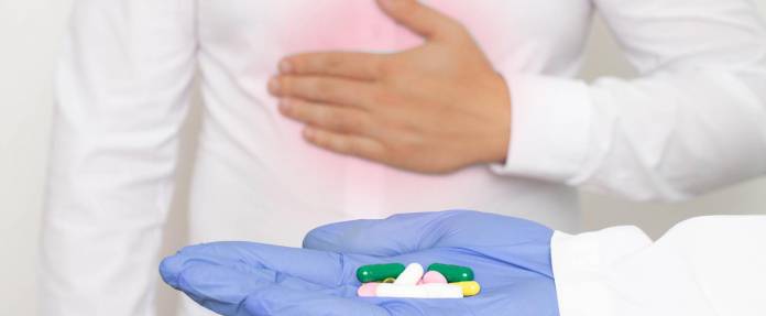 Mann mit Oberbauchschmerzen bekommt Tabletten vom Arzt