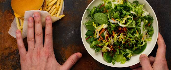 Auswahl zwischen gesundem Salat und Fast Food