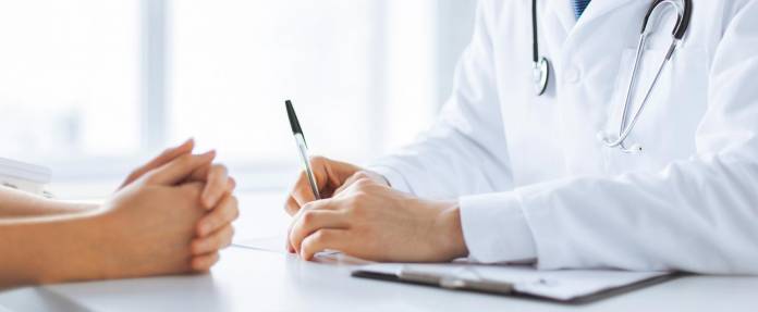 Arztgespräch mit Nahaufnahme der Hände von Arzt und Patientin