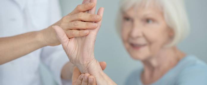 Seniorin bei Physiotherapie der Hand