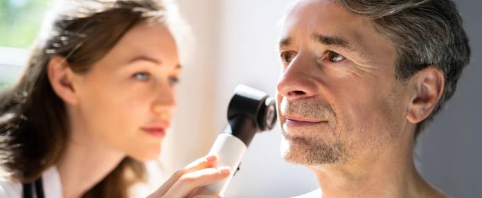 Mann bei Hautkrebs-Screening im Gesicht durch Hautärztin