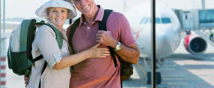 Älteres Ehepaar steht im Terminal vor einer Flugreise