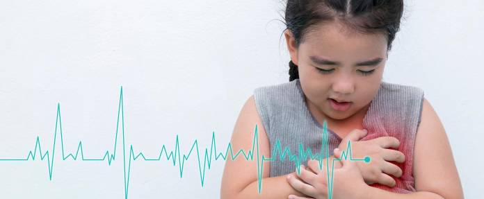 Kleines Mädchen fasst sich an die Brust mit Schmerzen