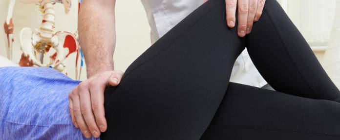 Frau bei Rehabilitationsmaßnahme durch Physiotheraputen