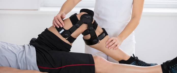 Mann mit Orthese bei der Physiotherapie