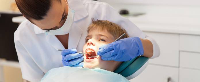 Zahnärztin bei Zahn-Behandlung eines Jungen