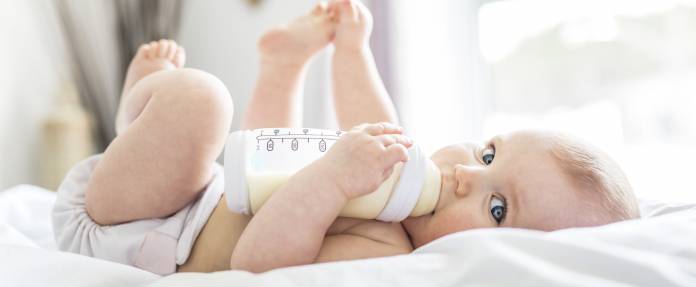 Baby mit Fläschchen im Mund