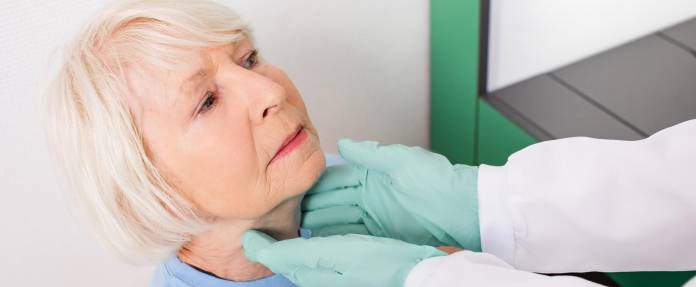Ältere Frau bei einer Schilddrüsenkontrolle durch den Arzt