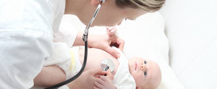 Kinderärztin bei Untersuchung eines Neugeborenen