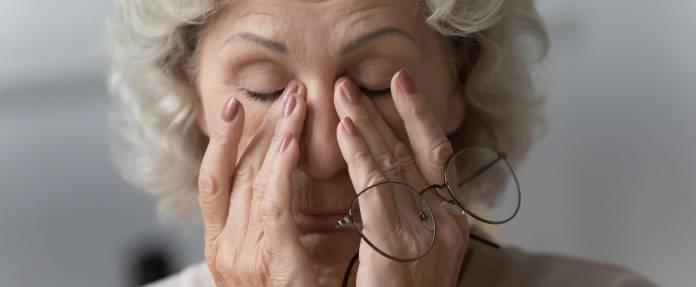 Ältere Frau reibt sich die Augen