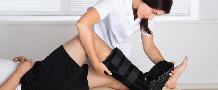 Patient mit Vorfußentlastungsschuh bei Krankengymnastik