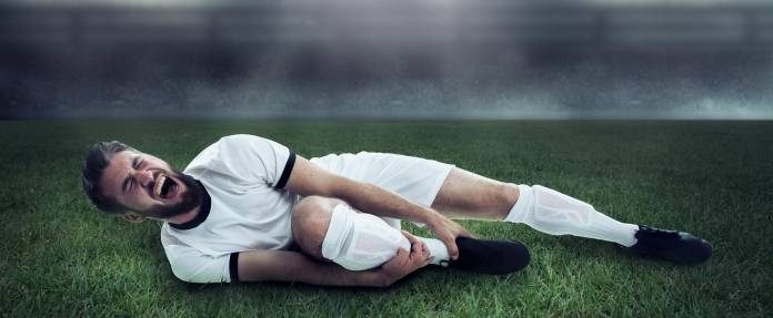 Fußballspieler liegt mit Schmerzen am Boden