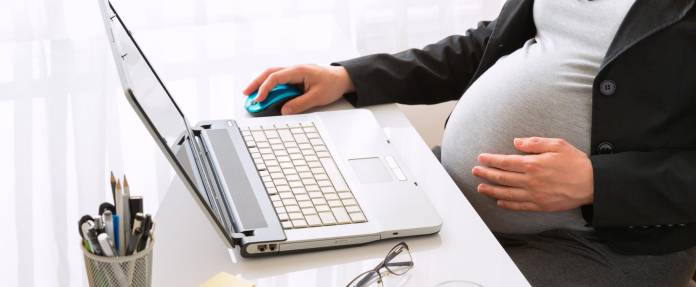 Schwangere Frau am Büroarbeitsplatz
