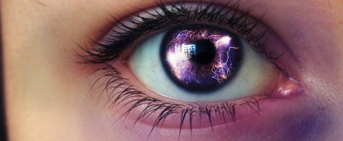 Auge einer Frau, auf dessen Pupille man Blitze sieht
