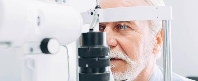 Älterer Mann bei Augenuntersuchung an Messgeraet