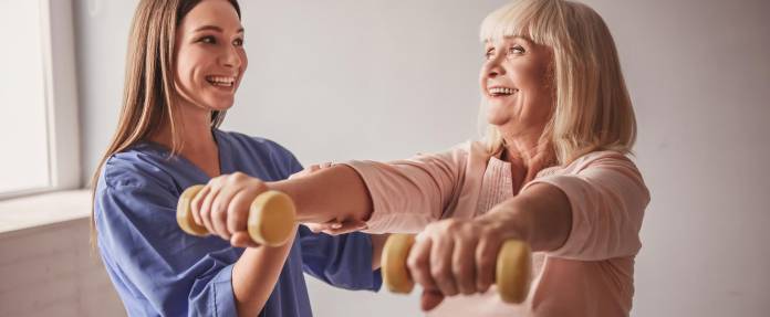 Ältere Frau bei Hantelübungen mit Physiotherapeutin