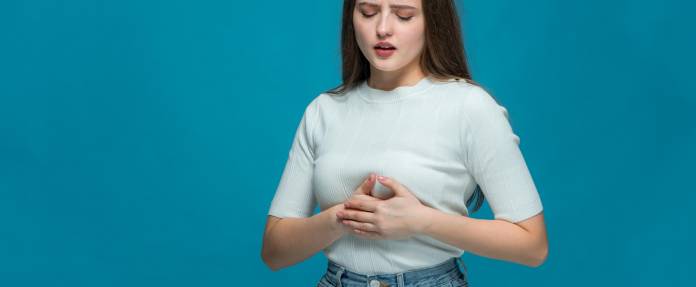 Junge Frauen mit Schmerzen unter der Brust