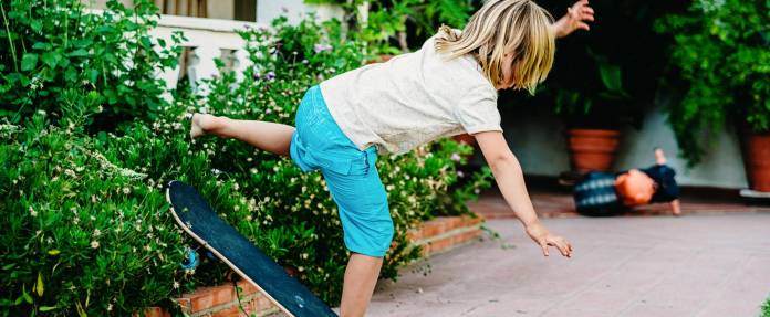 Kind fällt beim Skateboardfahren
