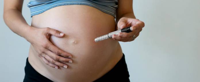 Schwangere Frau mit Insulin-Injektion in den Bauch