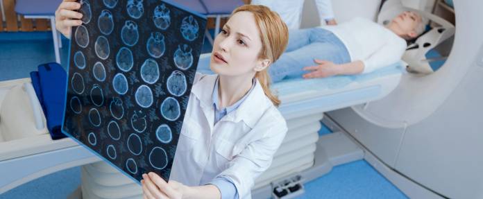 Junge Radiologin schaut sich MRT-Aufnahmen an