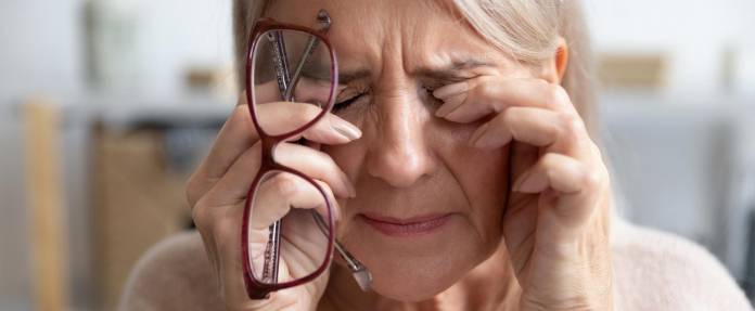 Ältere Frau mit Kopfschmerzen und Händen vor den Augen