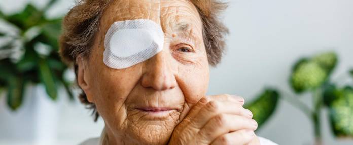 Ältere Frau mit Augenpflaster nach OP