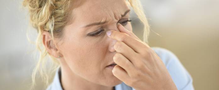 Frau, die an einer Sinusitis leidet