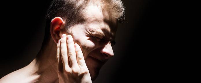 Mann mit Ohrenschmerzen bzw. Tinnitus