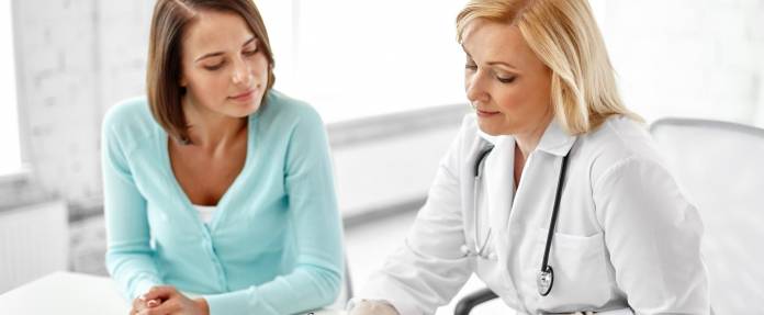Junge Frau lässt sich von Ärztin beraten