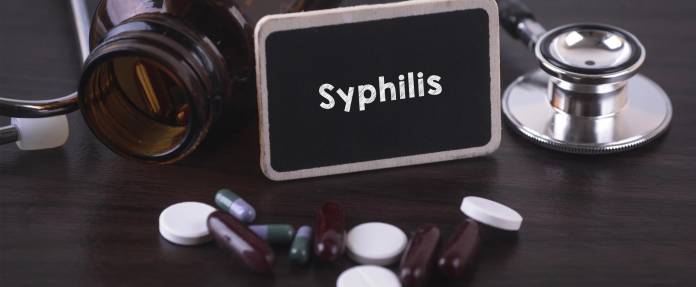 Medikamente, Stethoskop, Medikamentenfläschchen und Tafel mit Aufschrift Syphilis