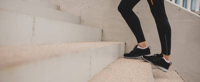 Frau beim Dehnen der Waden auf Treppe