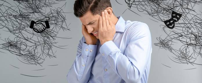 Mann hält sich den Kopf, weil er Stress hat